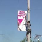 Street Protester removing Sign of President Michel Martelly