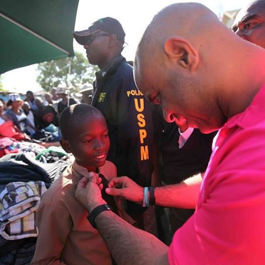 Prime Minister Laurent Lamothe fixing the Tie of a young Child