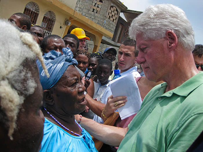 Bill Clinton listening to a woman in Haiti